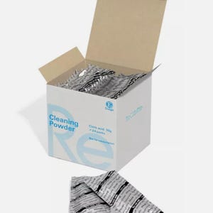 以下が含まれることがあります： 白い箱に「Cleaning Powder」と「Citric Acid 30g x 24 packs」の文字が書かれています。箱が開いており、小さな白い袋が黒文字で書かれています。袋には「Cleaning Powder」とラベルが貼られています。