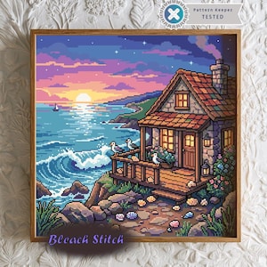 May include: A square pixel art print featuring a coastal cottage at sunset. The scene depicts a stone house with a wooden porch, three seagulls, and a rocky shoreline overlooking a blue ocean with waves. The sky is a gradient of purple and orange.