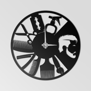 Puede incluir: Reloj de barbería de metal negro con herramientas de barbero como tijeras, navajas, peines y un pulverizador. Las manecillas del reloj indican la hora. También se incluye una silueta de un hombre con barba.