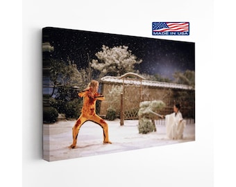 May include: A rectangular canvas print depicting a scene in the snow with a person in a yellow tracksuit holding a sword and another person in a white robe holding a sword. The top right corner features a small American flag icon with the text MADE IN USA.