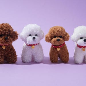 May include: Four plush toy poodle dogs in shades of brown and white are arranged on a purple background. Each dog wears a red collar with white polka dots and a gold-colored tag. The dogs have fluffy, curly fur.