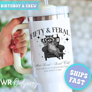 May include: White insulated tumbler with a handle, featuring a raccoon illustration holding a wine glass and bottle. Text reads "FIFTY & FERAL" and "Anti-Social - Social Club". Includes a straw and a lid. The tumbler is approximately 10 inches tall.