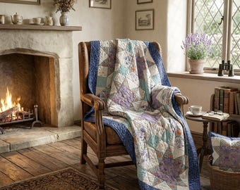 May include: A wooden armchair draped with a patchwork quilt featuring star patterns in shades of blue, purple, and white. The quilt has a dark blue border and is made of fabric squares with floral and geometric prints. A matching pillow sits nearby.