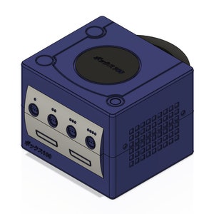 May include: A blue Nintendo GameCube console with a black disc drive and a silver faceplate. The console has a ventilation grill on the right side and the text "GameCube" in Japanese on the front and top.