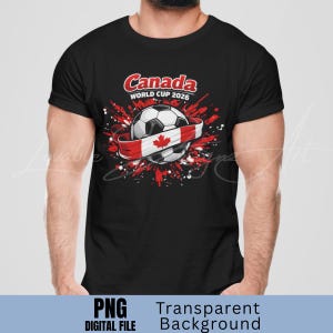 Puede incluir: Camiseta negra con un bal&oacute;n de f&uacute;tbol envuelto en una cinta roja y blanca con un dise&ntilde;o de la bandera canadiense. El texto "Canada WORLD CUP 2026" es rojo. Salpicaduras de pintura roja rodean el bal&oacute;n.