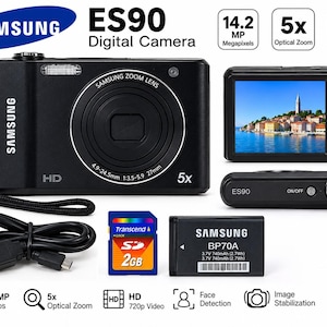 Op de afbeelding: Een zwarte Samsung ES90 digitale camera met 5x optische zoom, 14,2 megapixels en HD 720p video-opname. De set bevat een zwarte polsband, een USB-kabel, een 2GB Transcend SD-geheugenkaart en een oplaadbare Samsung BP70A batterij.