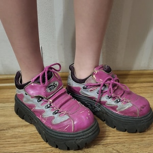 Puede incluir: Zapatillas de plataforma rosa y gris con cordones negros y la palabra "ROXY" en el lateral.
