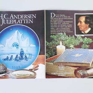 May include: A blue and white Christmas plate featuring a winter scene with a group of dogs and a person standing in front of an ice cave. The plate is part of a collection of plates featuring the works of H.C. Andersen. The plate is dated 1981.