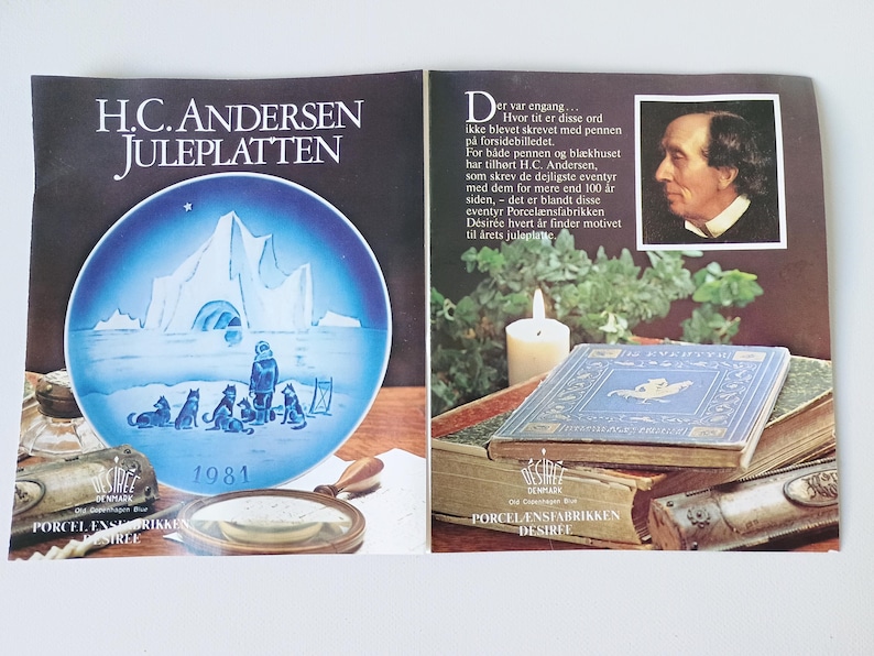 May include: A blue and white Christmas plate featuring a winter scene with a group of dogs and a person standing in front of an ice cave. The plate is part of a collection of plates featuring the works of H.C. Andersen. The plate is dated 1981.