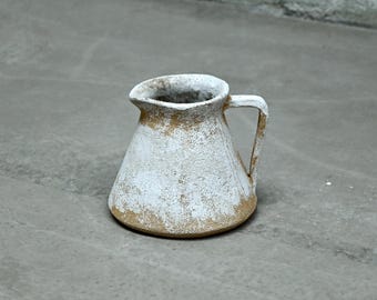 Karaf van roodbruin aardewerk, versierd met een witte glazuurlaag.