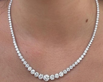 May include: A silver necklace with a row of round, clear diamonds.