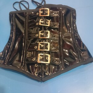 May include: Black patent leather corset with gold-toned buckles and lace-up front.