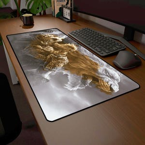 May include: A rectangular mouse pad featuring a detailed illustration of a golden armored figure with a lion's mane against a cloudy gray background. The mouse pad has a black border and is designed for use with a computer mouse and keyboard.