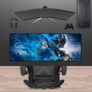 May include: A gaming setup featuring a curved monitor, headset, and a desktop computer. A large rectangular mousepad displays a fantasy warrior design with blue and white hues. A black gaming chair is positioned below the desk.