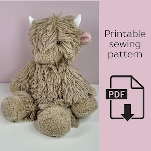 Puede incluir: Un peluche de vaca de las Tierras Altas con pelaje largo y marrón claro, cuernos blancos y orejas rosas. La imagen incluye el texto "Patrón de costura imprimible" y un icono PDF, lo que sugiere un patrón para crear el juguete.