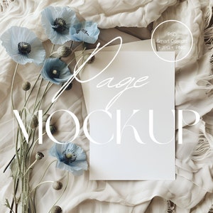 May include: A styled mockup with a blank white page, featuring the words "Mockup" and "Page" in white script. Light blue poppy flowers and buds are arranged on a beige fabric background. The image includes a circle with the text "PSD Smart Objects + JPG + PNG".