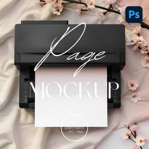 May include: A black printer with a white sheet of paper in the tray. The paper has the word "MOCKUP" printed on it in a white sans-serif font. The printer is on a pink and white fabric background with pink flowers.
