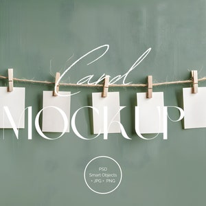 May include: Five blank white cards are hanging from a string with wooden pegs against a green background. The cards are arranged in a row and the text "Card Mockup" is written in white letters across the cards.