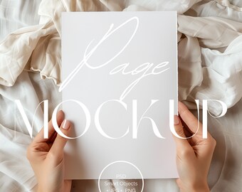 Puede incluir: Una maqueta de página blanca con la palabra "Page" escrita en cursiva y la palabra "MOCKUP" en negrita, sin serif. La página está siendo sostenida por una mano sobre un fondo de tela blanca.