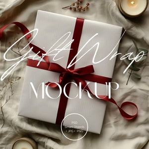 Może przedstawiać: Biały papier do pakowania prezentów z czerwoną satynową wstążką zawiązaną w kokardę. Tekst "Gift Wrap Mockup" jest napisany na białym papierze do pakowania prezentów. Papier do pakowania prezentów leży na białym tle z tkaniny.
