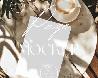 Puede incluir: Una hoja de papel blanca con el texto "Page Mockup" sobre una mesa de madera con una taza de café y una planta en el fondo.