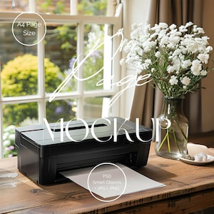May include: A black printer with a white sheet of paper coming out of the paper tray. The printer is on a wooden table with a vase of white flowers and a white saucer with a few white stones on it. The text "PSD Smart Objects .JPG .PNG" is on the paper.