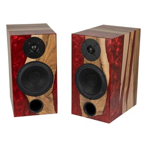 May include: A pair of wooden speaker cabinets with red and brown wood grain patterns. Each speaker has two black drivers, one large and one small.