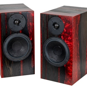 May include: A pair of black and red wooden speaker cabinets with black speaker cones and silver accents.