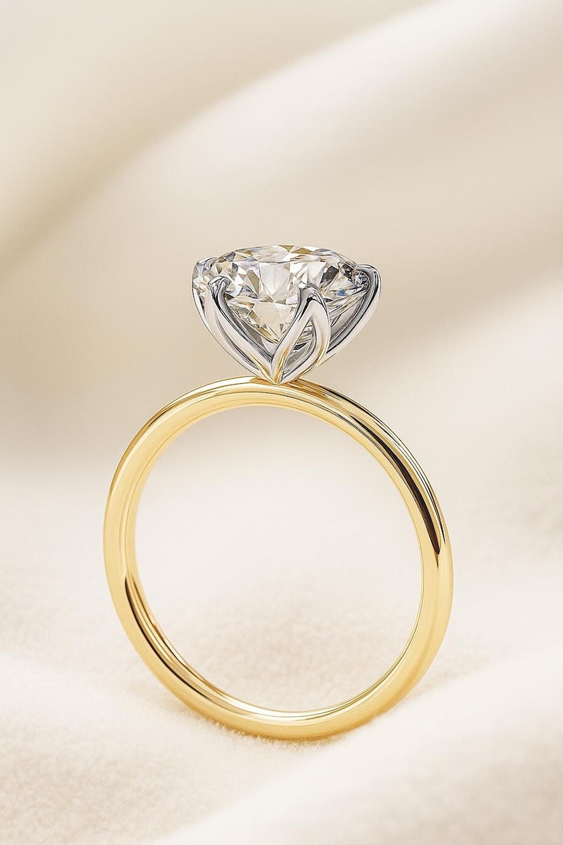 Profile view of a high-set round stone on a 14k gold solitaire engagement ring, minimal prong setting, elegant.