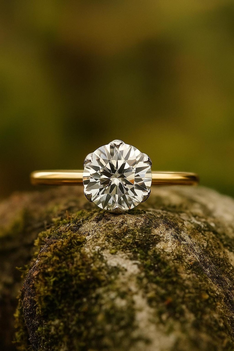 Rustic close-up on moss, 2 carat solitaire engagement ring in warm yellow gold, brilliant round lab diamond look.
