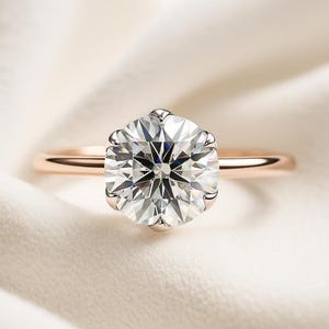 Top-down view of a 2 carat lab grown diamond engagement ring, round solitaire on a thin rose gold band.