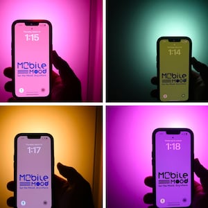 May include: A smartphone displaying the Mobile EMOOD app with the text "Set the Mood. Anywhere." The phone is held in a hand against a pink background.