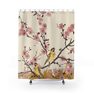 May include: Shower curtain featuring a watercolor illustration of two yellow birds perched on branches with pink cherry blossoms. The background is a cream color with a gold-colored textured area at the bottom.