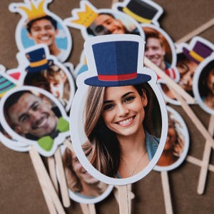 May include: A set of photo booth props featuring various hats and faces. The props are printed on white cardstock and attached to wooden sticks. The props are perfect for adding a fun and festive touch to any party or event.