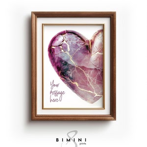 Può includere: Una stampa incorniciata di un cuore rosa e oro con crepe. Il testo "Your message here" è scritto sotto il cuore.