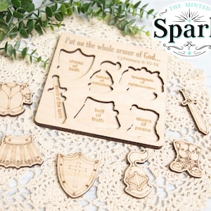 Puede incluir: Rompecabezas de madera con un recorte de una armadura de caballero y el texto "Ponte toda la armadura de Dios... Efesios 6:10-18". Las piezas del rompecabezas incluyen una espada, un escudo, un casco, una coraza, un cinturón y zapatos.