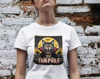 May include: A white t-shirt with a black cat wearing a red cape and fangs. The cat is in front of a yellow moon and a dark castle. The text "Night of the Vampurr" is printed on the shirt.