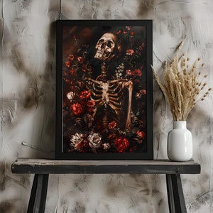 May include: A framed print of a human skeleton surrounded by red, white, and pink flowers. The skeleton is positioned upright with its head tilted back, and its ribcage is visible. The flowers are arranged around the skeleton in a way that suggests they are growing from its bones.