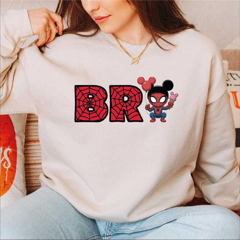 A woman wearing a white sweatshirt with the text "BR" and a Spider-Man character on it.
