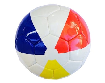 Könnte beinhalten: Ein weißer Fußball mit blauen, roten und gelben Feldern. Der Ball hat ein klassisches Design mit einem traditionellen Feldmuster.