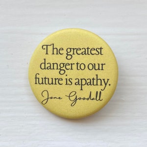 May include: A yellow button with the quote "The greatest danger to our future is apathy." by Jane Goodall.