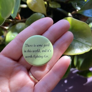 May include: A green button with the text "There is some good in this world, and it's worth fighting for."