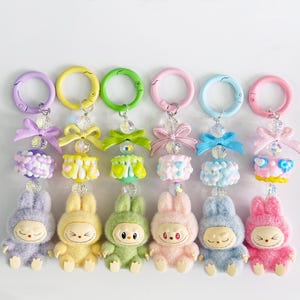 Niedliches Labubu Schlüsselanhänger, Kawaii Labubu Zubehör, 6 Farben Autoschlüssel / Geldbeutel / Taschenanhänger, sitzende Mini Labubu Puppe, Monster inspiriert, Geschenk für Labubu Liebhaber