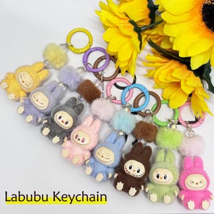 Niedliches Labubu Schlüsselanhänger, Kawaii Labubu Zubehör, 8 Farben Autoschlüssel / Geldbeutel / Taschenanhänger, Mini sitzende Labubu-Puppe, Monster-inspiriert, Geschenk für Labubu-Liebhaber