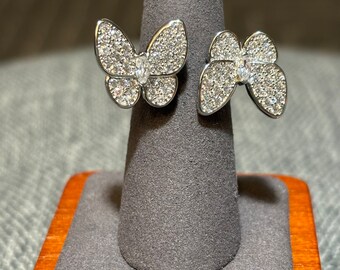 Bague entre doigt deux papillons, diamants argentés bling bling