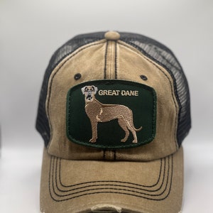 Può includere: Un cappello da camionista marrone e nero con una toppa verde che presenta un Great Dane ricamato. La toppa ha il testo "Great Dane".