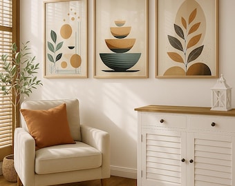 Puede incluir: Tres impresiones de arte abstracto enmarcadas con formas geométricas y elementos orgánicos en tonos de marrón, beige y verde. Las impresiones están colgadas en una pared blanca sobre un armario blanco con dos cajones y dos puertas.