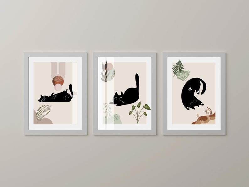 May include: Three framed prints with black silhouettes of cats in different poses against a beige background with abstract shapes and foliage.