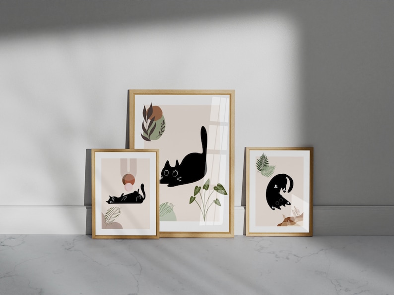 May include: Three framed prints with a minimalist design featuring black cats and abstract shapes in shades of brown, pink, and green.