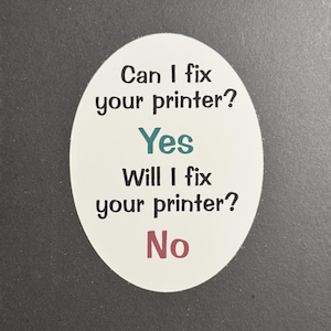 Op de afbeelding: Witte ovale sticker met zwarte tekst die "Can I fix your printer? Yes Will I fix your printer? No" luidt. Het woord "Yes" is in turquoise en het woord "No" is in roze.